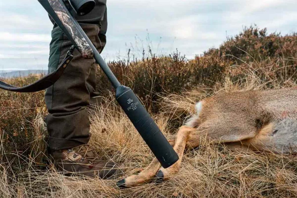Un cazador haciendo uso de un rifle con moderador de sonido