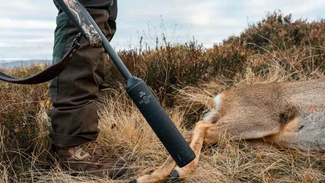 Un cazador haciendo uso de un rifle con moderador de sonido
