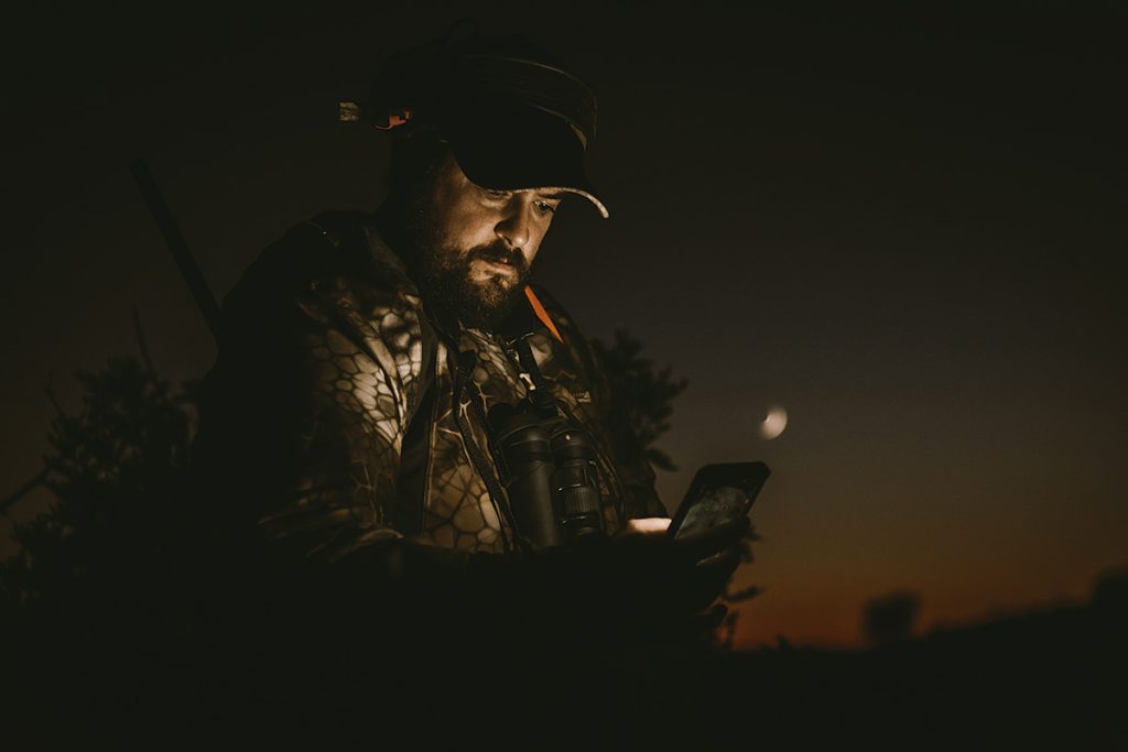 Un cazador usando su teléfono móvil.