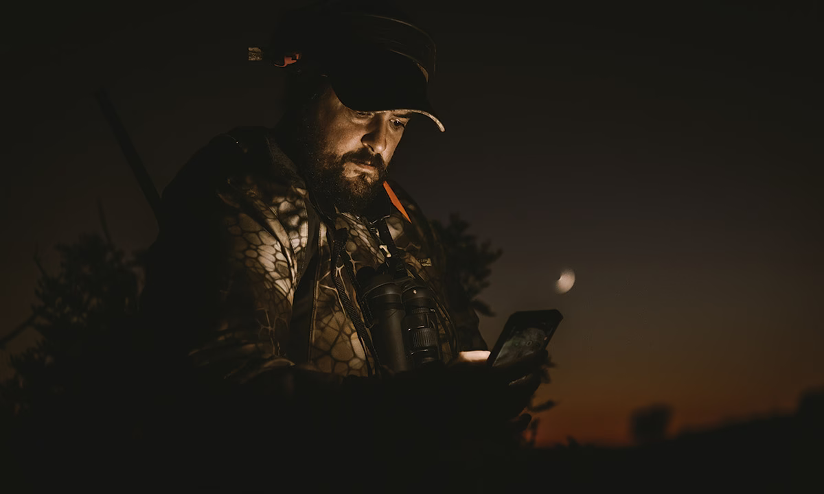 Un cazador usando su teléfono móvil.
