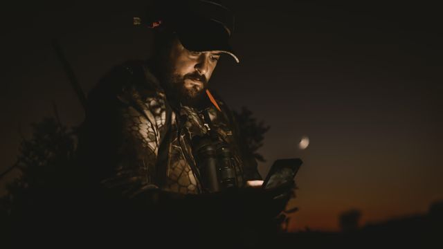 Un cazador usando su teléfono móvil.
