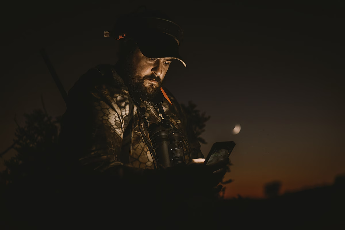 Un cazador usando su teléfono móvil.