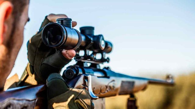 Un cazador disparando su rifle.