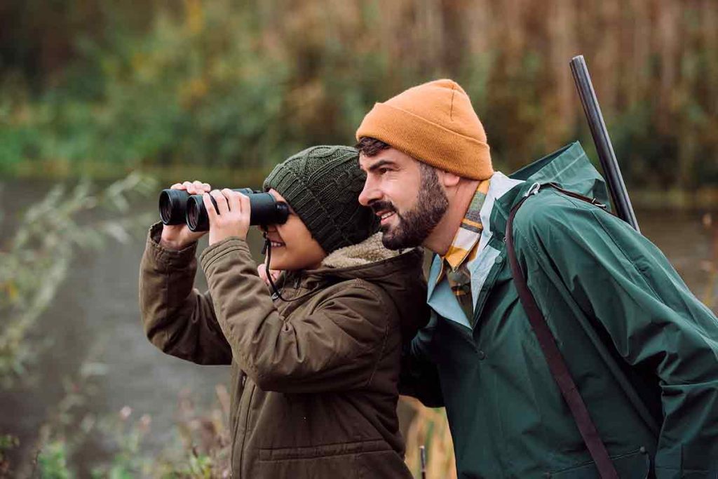 Un niño cazando junto a su padre.