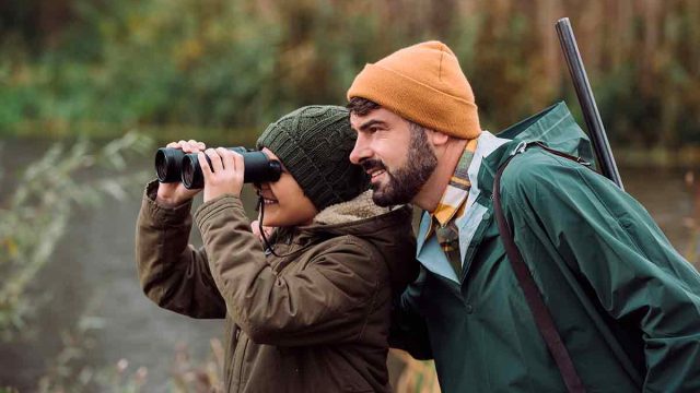 Un niño cazando junto a su padre.