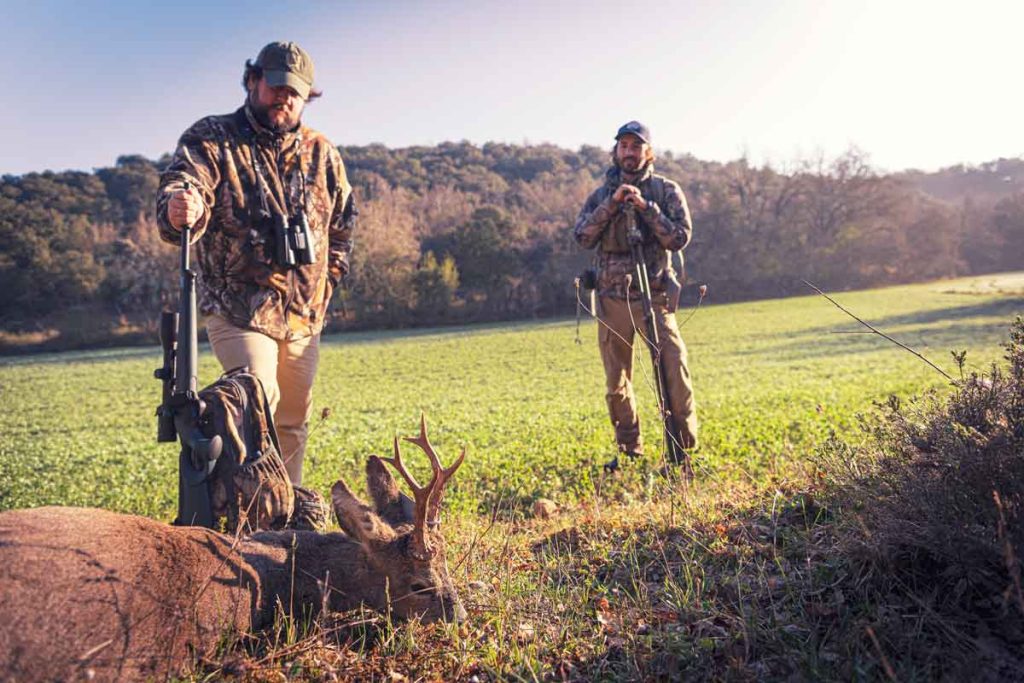 Cazador y guía con un corzo recién cobrado.