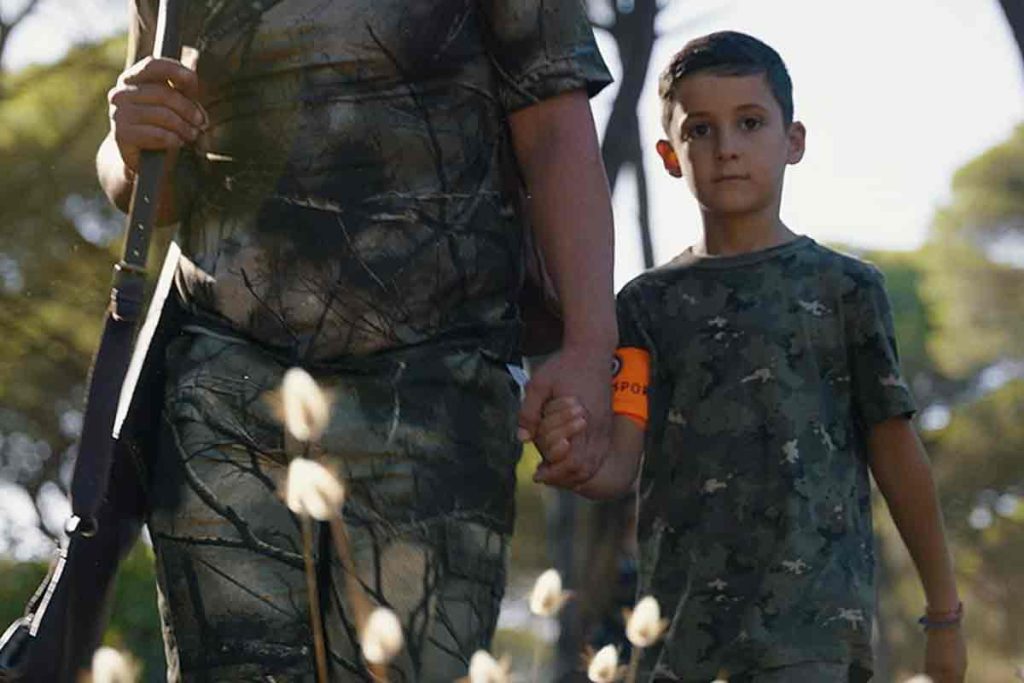 Un niño en compañía de su padre cazador.