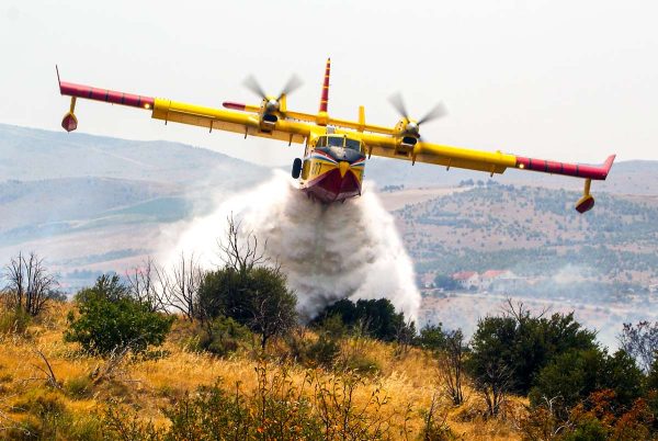 Un avión anti incendios libera su carga.