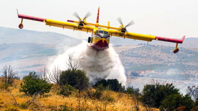 Un avión anti incendios libera su carga.
