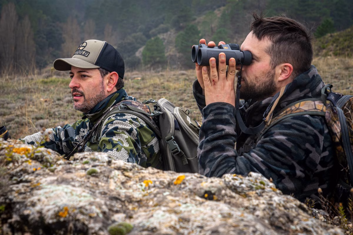Dos cazadores buscan una cabra montés.